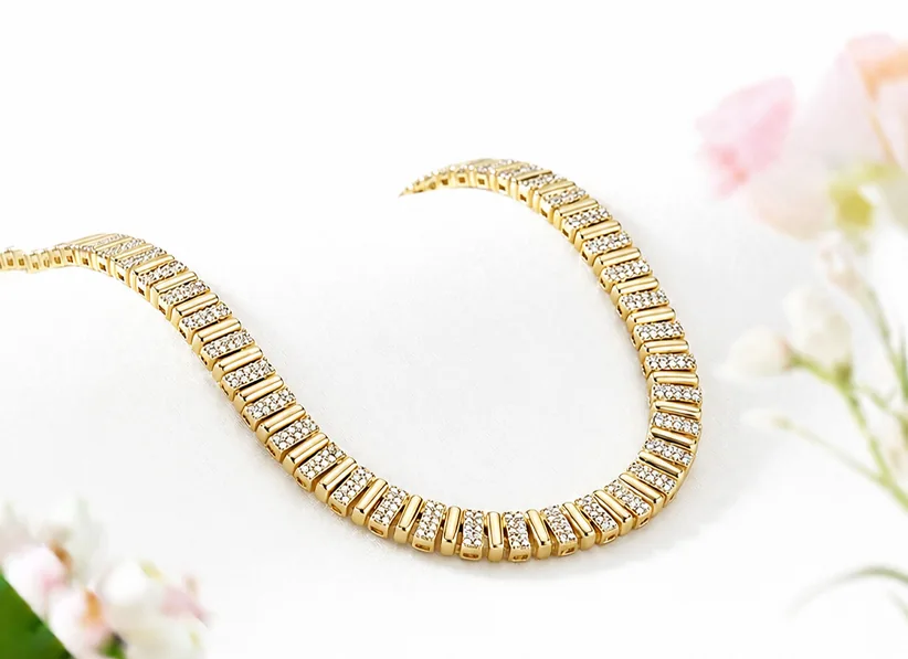 Gold and diamond necklace displayed on ivory fabric